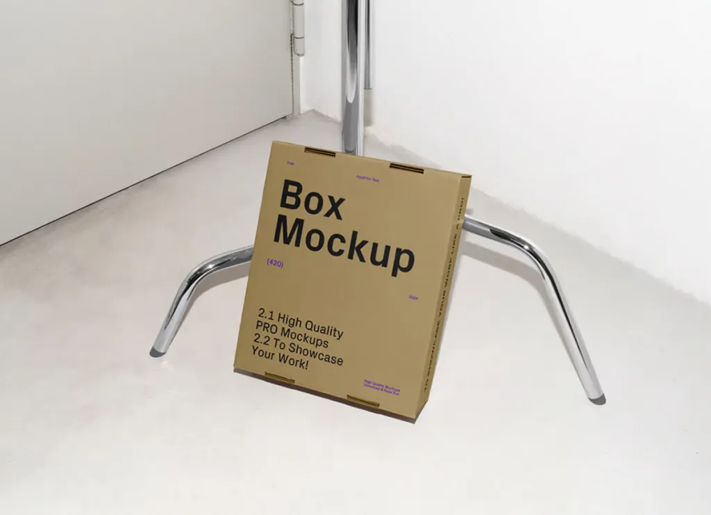 Free Cardboard Box Leaning Against the Tripod Mockup