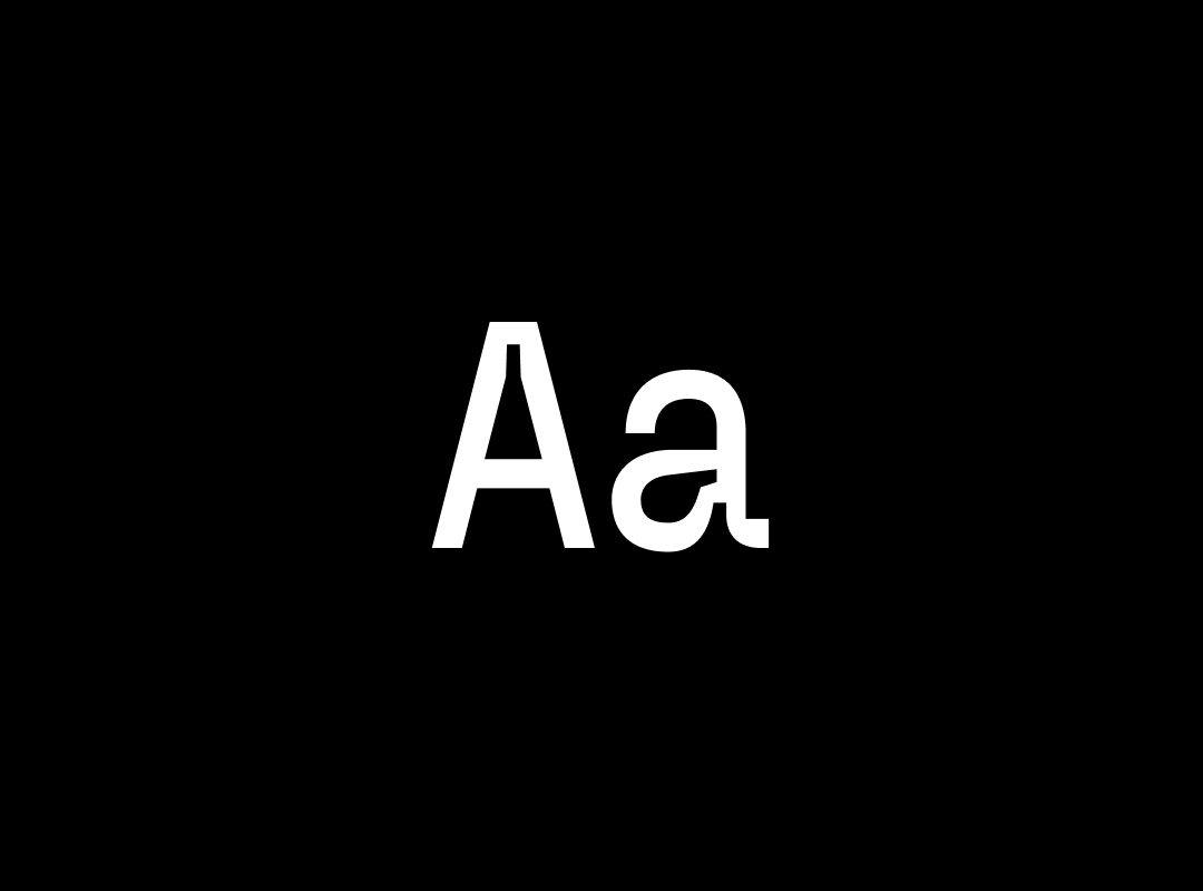 A close-up view of the letters "Aa" in the Fliege Mono font, a unique monospaced typeface, in a white color on a black background.