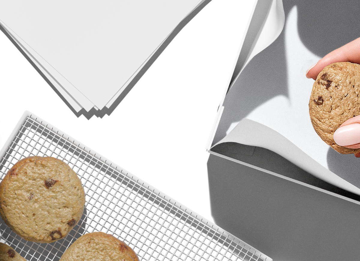 A collection of white and kraft bakery packaging items, including a square cake box and a paper bag, arranged on a neutral surface.