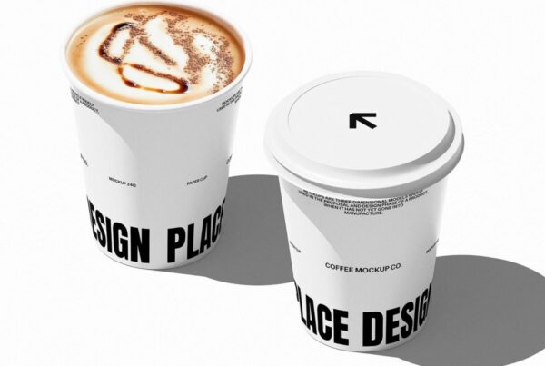 Two white disposable coffee cups on a plain white background, one filled with latte art and the other closed with a lid.