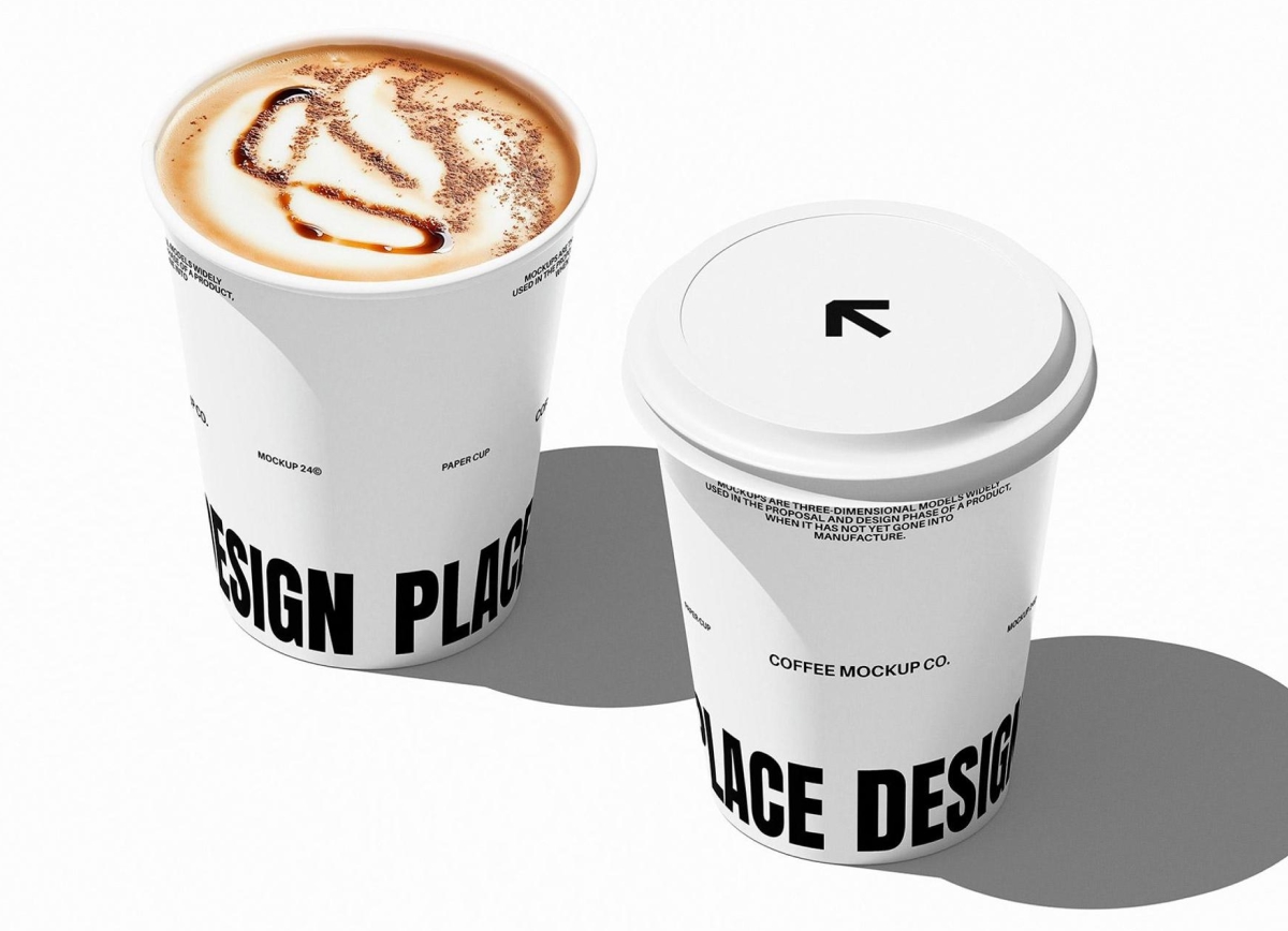 Two white disposable coffee cups on a plain white background, one filled with latte art and the other closed with a lid.