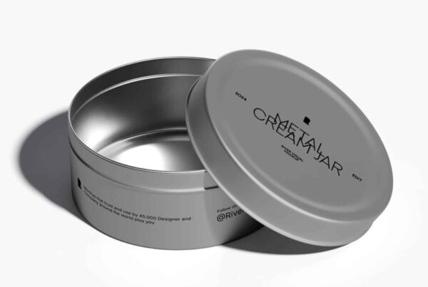 A single, empty silver metal cosmetic jar with its lid removed and placed beside it on a neutral surface.
