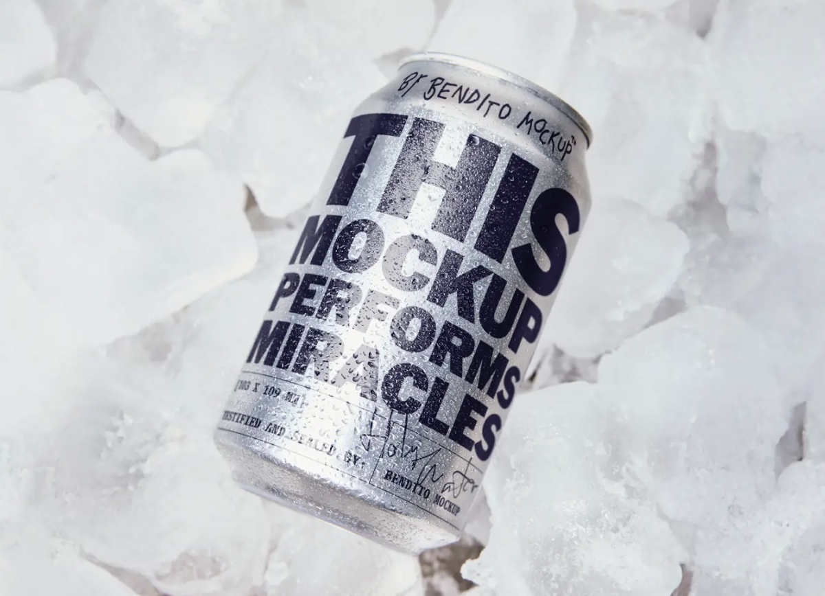 A condenting aluminum beverage can with bold black typography resting on a bed of clear crushed ice cubes.