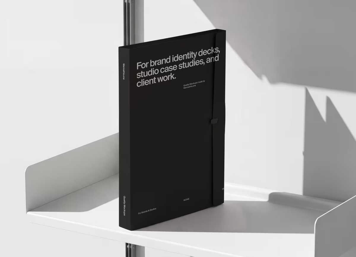 A black presentation folder with white typography standing upright on a minimalist white metal rail shelf.