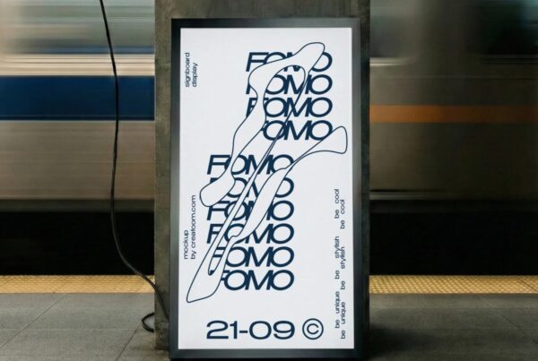 Front view of a customizable vertical display signboard standing on a tiled subway platform with a blurred train moving in the background.